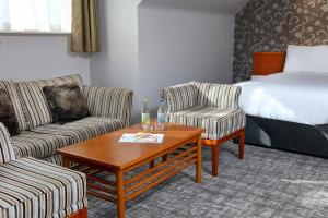 una camera d'albergo con due sedie e un letto di Best Western Nottingham Derby a Long Eaton