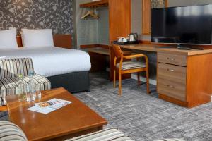 Pokój hotelowy z łóżkiem i biurkiem z telewizorem w obiekcie Best Western Nottingham Derby w mieście Long Eaton
