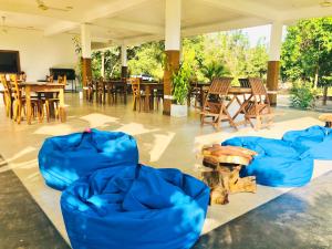 Habitación con sillas azules, mesas y sillas en Into The Wild Sigiriya en Sigiriya