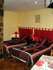 フレジュスにあるMas Aurélia B&Bのベッドルーム1室(赤いヘッドボード付きのベッド2台付)