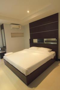 a bedroom with a large bed with a large headboard at Smith Residence in Suratthani +24 photos