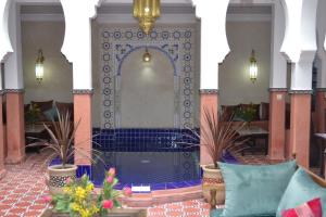 un hall avec une fontaine ornée de plantes en pot dans l'établissement Riad le Voile d'Orient, à Marrakech