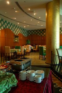 a dining room with a table with dishes on it at Ewan Hotel Sharjah in Sharjah