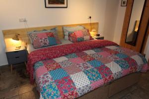 a bed with a quilt and two pillows on it at Lynton Lodge Studios in Keswick