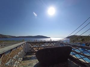 a chair on a balcony with a view of the water at Alexandros by the Beach - Serifos in Livadakia