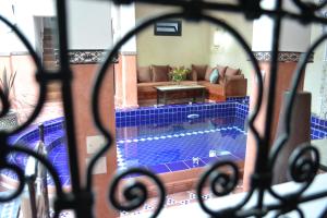 Blick auf den Pool aus dem Fenster in der Unterkunft Riad le Voile d'Orient in Marrakesch