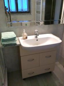 bagno con lavandino bianco e specchio di L'impossibile Guesthouse ad Appiano Gentile