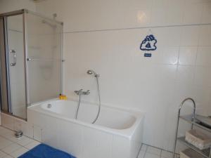 a bathroom with a shower and a tub with a glass door at Ferienhaus "NordseeZeit" in Burhave +14 photos