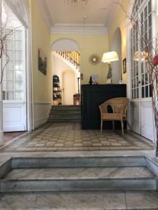 a hallway of a building with a chair and stairs at Hotel Alexandra - Boutique Hotel in Juan-les-Pins