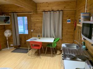 uma cozinha com uma mesa e cadeiras num camarote em Southernwood - Garden Lodge 1 em Didcot