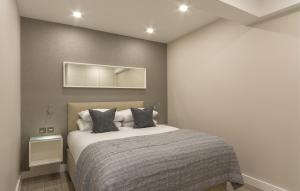 um quarto com uma cama e um espelho na parede em Chelsea Cloisters em Londres