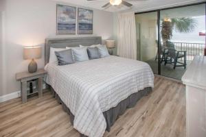 une chambre avec un grand lit et un balcon dans l'établissement White Caps 206, à Romar Beach