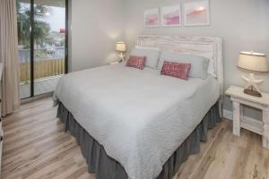 une chambre avec un grand lit blanc avec deux lampes dans l'établissement White Caps 206, à Romar Beach 41 autres photos