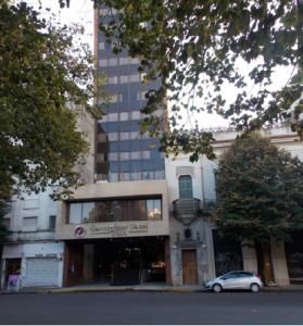 un coche está estacionado frente a un edificio en Hotel Corregidor en La Plata