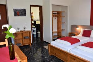 a bedroom with two beds and a table with a vase at Calma do Mar in Madalena