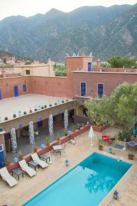 un hotel con piscina y montañas de fondo en Riad Malak, en Ouirgane