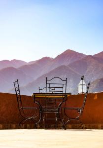 a table and two chairs with mountains in the background at Riad Malak in Ouirgane