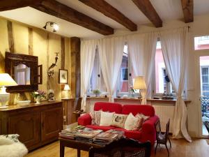 - un salon avec un canapé rouge et une table dans l'établissement Ombre Rose, à Le Fousseret