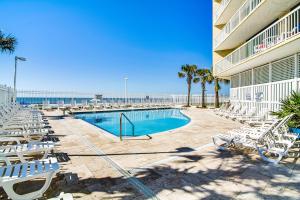 een zwembad met ligstoelen en het strand bij Charleston Oceanfront Villas in Folly Beach