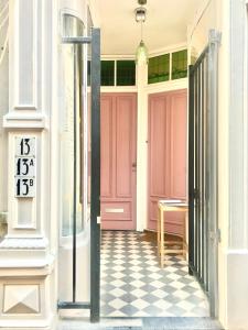 eine rosa Tür in einem Gebäude mit kariertem Boden in der Unterkunft Pearl of the Hague - R.Q.C. in Den Haag