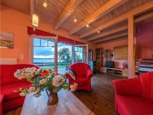 a living room with red furniture and a vase of flowers at Ferienhaus Uttied - direkt am Plauer See in Alt Schwerin