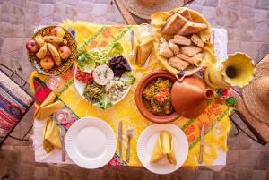 a table with plates of food on a yellow table cloth at Riad Malak in Ouirgane