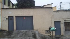 a building with two blue doors and a fire hydrant at Aconchego dos schreiber in Belo Horizonte