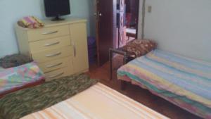 a bedroom with a dresser and a bed and a dresser at Aconchego dos schreiber in Belo Horizonte
