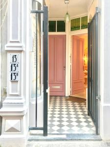 a pink door on a white building with a checkered floor at The Royal Suite II - R.Q.C. in The Hague
