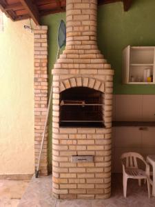 a brick oven in a kitchen with a chair at LINDO SOBRADO COM PISCINA PARA ATÉ 10 HÓSPEDES! in Natal