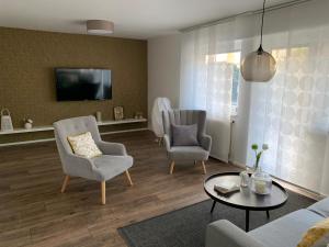 sala de estar con 2 sillas y TV en Casa Peppino, en Friedrichshafen