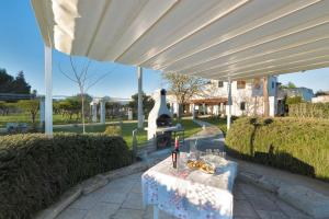 a table with a bottle of wine on it under an umbrella at Casina Farnarari by BarbarHouse in Monteroni di Lecce