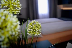 a table with flowers on it with a bed at Pension Elisabeth - Rooms & Apartments in Salzburg