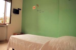 a bedroom with a bed and a green wall at Locanda Del Centro in Cambiano