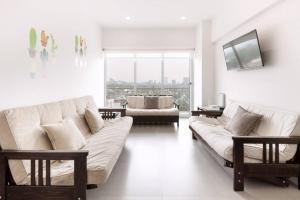 a living room with two white couches and a large window at San Ángel - UNAM apartment 2parking 3BR 2BA in Mexico City