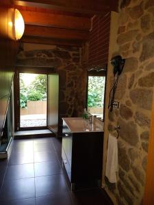 a kitchen with a sink and a stone wall at CAPELA DA GRANXA in Pontevedra