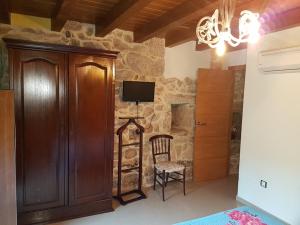 a room with a wooden cabinet and a tv at CAPELA DA GRANXA in Pontevedra