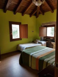 Dos camas en una habitación con paredes y ventanas verdes. en CAPELA DA GRANXA, en Pontevedra
