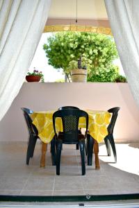 une table et des chaises noires avec un chiffon de table jaune dans l'établissement Kakia 2 Bedroom Apartment, à Zante