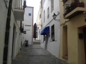 un callejón con toldo azul en un edificio en Vehí en Cadaqués