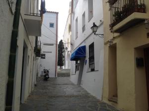 an alley with a blue awning on a building at Vehí in Cadaqués
