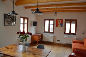 a living room with a table and a desk at Dreiseitenhof Radebeul in Radebeul