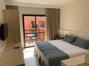 a hotel room with a bed and a balcony at Jurerê Beach Village - Flat na Praia in Florianópolis