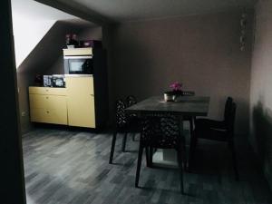 a dining room with a table and chairs and a kitchen at Caffe Boulevard Apartmá in Waldsassen