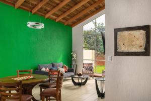 a living room with a green wall and a table at Casa Sofia, every stay comes with a free professional massage in Orosí