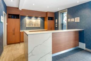 a kitchen with a counter and wooden cabinets at Quality Inn Centre-Ville in Montréal