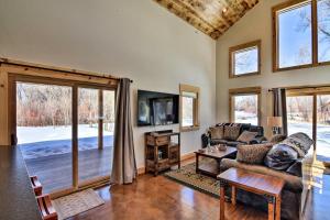 a living room with a couch and a tv at Riverfront Home with BBQ 2 Mi to Downtown Gunnison! in Gunnison