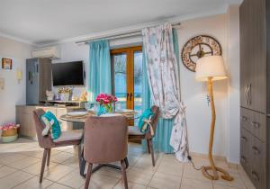a dining room with a table and chairs and a television at Seastar seafront villa in Kalamaki