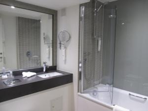 a bathroom with a shower, sink, and mirror at Holiday Inn Slough Windsor, an IHG Hotel in Slough