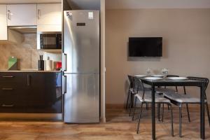 a kitchen with a refrigerator and a table with chairs at Studio Alboran in Salou